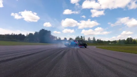 Back view of a car drifting on a circuit with smoke and dangerous curves. Stock Footage 106028958