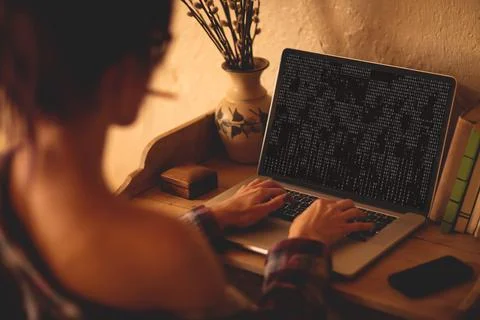 Back view of caucasian female programmer sitting at desk, using laptop with 스톡 사진