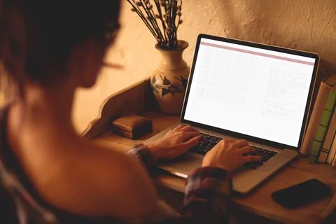 Back view of caucasian female programmer sitting at desk, using laptop with 스톡 사진