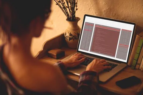 Back view of caucasian female programmer sitting at desk, using laptop with 스톡 사진