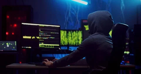 Back view on the Caucasian man in hood working as a hacker and commiting Video stock 124347662