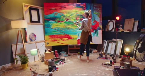Back view of Caucasian young talented female painter working in cozy workshop in Stock Footage 149578553