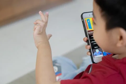 Back view of child boy looking on mobile screen. Educational online program.. Stock Photos