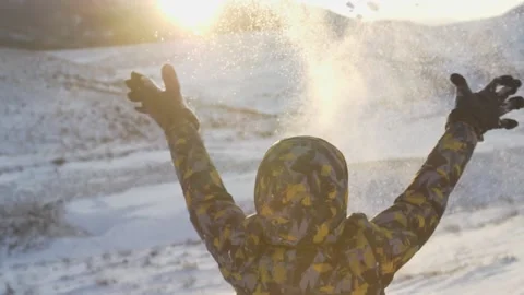 Back view of a child who throws snow with his hands against the background of sn Stock Footage 151154244