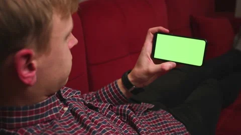 Back view close up man hands holding chromakey green screen smartphone watching Stock Footage 146599015