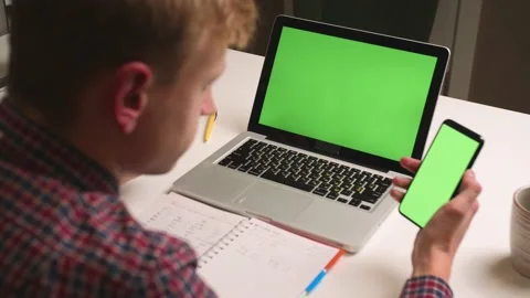 Back view. Close up man use laptop green screen holding phone chromakey at home 스톡 동영상 146613002