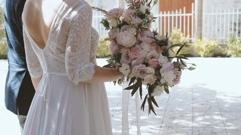 Back view of couple bride and  bridegroom in wisteria flowers  park  Video stock 90796957