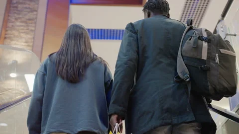Back View of Couple on Escalator Holding Shopping Bag Stock Footage 319918652
