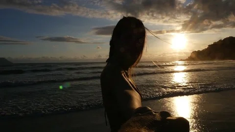 Back view of a couple having fun and holding hands on the beach - Slow Motion Stock Footage