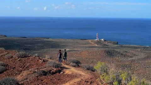 Back view of a couple of hikers looking to  to the lighthouse of Rasca Stock Footage 204893525