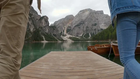 Back view of couple holding hands while walking along bridge Stock Footage 128215864