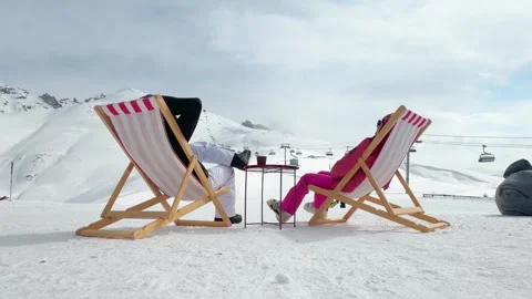 Back view couple relaxing with hot drinks on deck chairs overlooking snowy .. Stock Footage 342962246