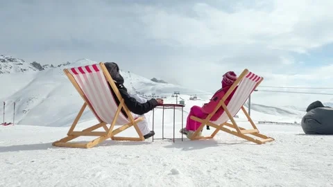 Back view couple relaxing with hot drinks on deck chairs overlooking snowy .. Stock Footage 343556670