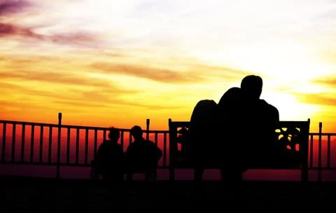 Back view of a couple silhouette hugging and watching sun on the mountain Stock Photos