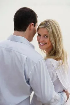 Back view of couple standing arm in arm Stock Photos