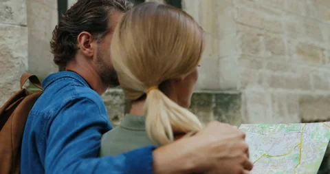 Back view on the couple of tourists walking the town street and hugging with Stock Footage 139504595