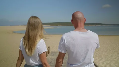 Back view of couple walking on beach together Stock Footage 107401973