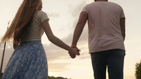 Back view of a couple walking hand in hand in summer spending active weekend Stock Footage 250236550