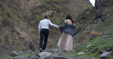 Back view. Couple walking on the mountain range. Video stock 96645710