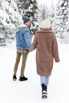 Back view of couple walking in winter park or forest Stockfoto's