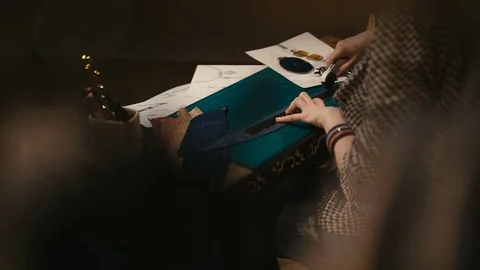 Back view of the craftsman's hands cut off a piece of leather Stock-Footage 73951012