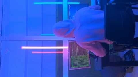 Back view of criminal hacker working in the evening on computer in big office Stock Footage 129874753