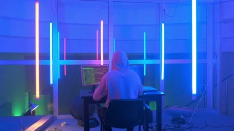 Back view of criminal hacker working in the evening on computer in big office Stock Footage 130657212