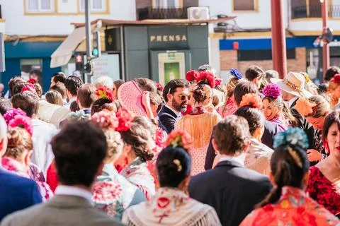 A back view of a crowd of people dressed in flamenco dresses on a city street Stock Photos