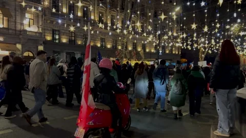 Back view. Crowd of people with Georgian flag walk on city street Stock Footage 320981927