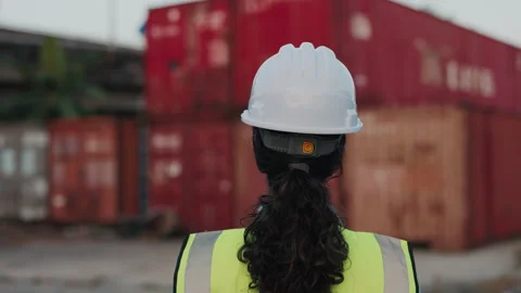 Back View of the Curly Haired Latino Girl Worker in Safety Vest Walking Between Stock Footage 308727119