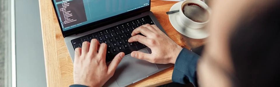 Back view of developer programmer freelancer working on project in cafe. Blurred Stock Photos