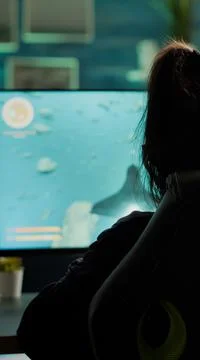Back view of digital pro player playing online space shooter video game Stockfoto's