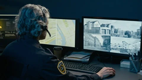 Back View Dispatcher at Police Command Center Speaking to Headset Stock Footage 330606317