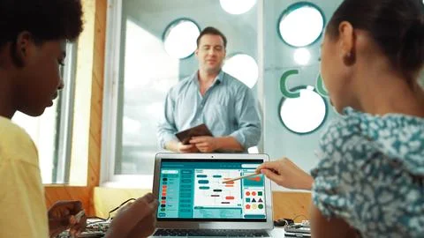 Back view of diverse student code system while pointing at screen. Edification. Stock Photos