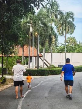 Back view of elderly father and little son or grandfather and grandson walk.. Stock Photos