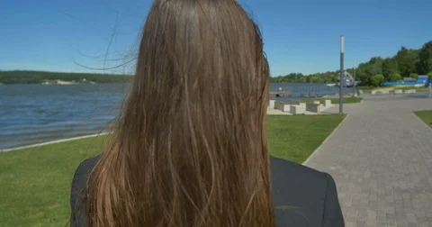 Back view of elegant woman walking in the park Stock Footage 77611287