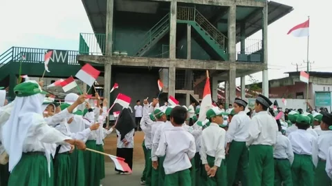 Back view of elementary school students waving Indonesian flag Stock Footage 245992770