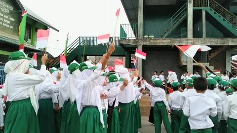 Back view of elementary school students waving Indonesian flag Stock Footage 246019553