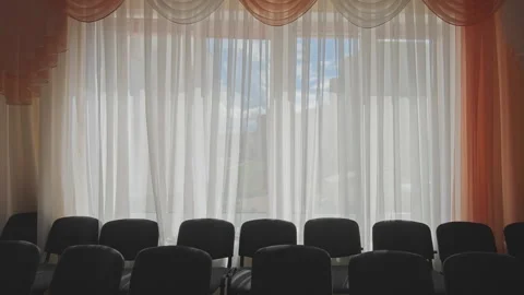 Back view of empty chairs in an empty conference hall. The wind gently moves Stock Footage 344814388