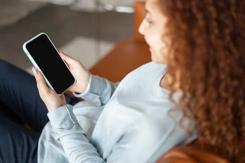 Back view at an empty smartphone screen in hand of a woman Foto stock
