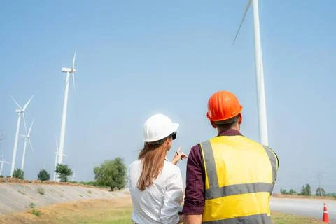 Back view of engineer and architect on construction site with wind turbine... Foto stock