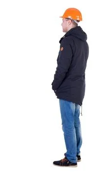 Back view of an engineer in construction helmet stands. Back view of an en... Foto stock