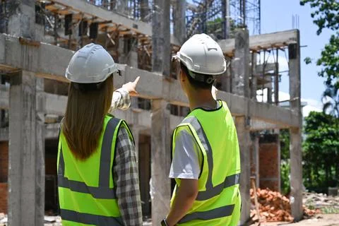 Back view engineer team wearing yellow vests discussing the construction process Foto stock