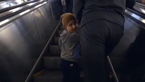 Back view of father and son going up on the escalator at the metro Video stock 75773198