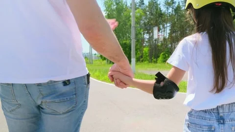 Back view father walking on street and supporting little daughter while she lear Stock Footage 282082939