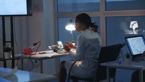 Back view of female electronics engineer checking motherboard with multimeter Stock Footage 112864884