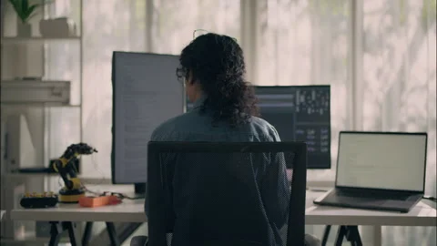 Back View of Female Engineer Working with Multi-Monitor Setup in Tech Lab. Stock Footage 307587599