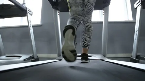 Back view of female legs walking and running on treadmill in gym, woman training Stockbeeldmateriaal 75220029