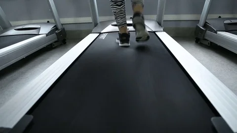 Back view of female legs walking and running on treadmill in gym, woman training Stock Footage 75220533