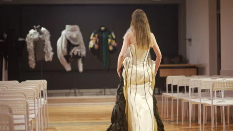 Back view of a female model walking in a structured corset style dress with Stock Footage 335349228